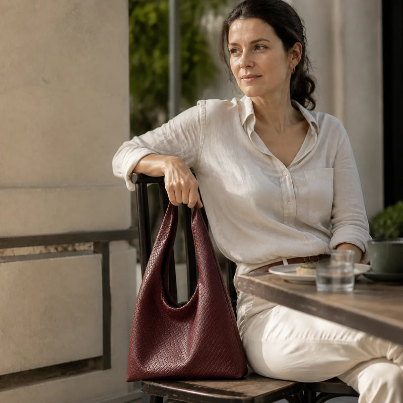 Woman carrying the Featherlight Woven Hobo bag on her shoulder, lifestyle photo