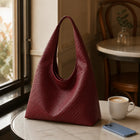 Featherlight Woven Hobo bag resting on a cafe table, lifestyle photo